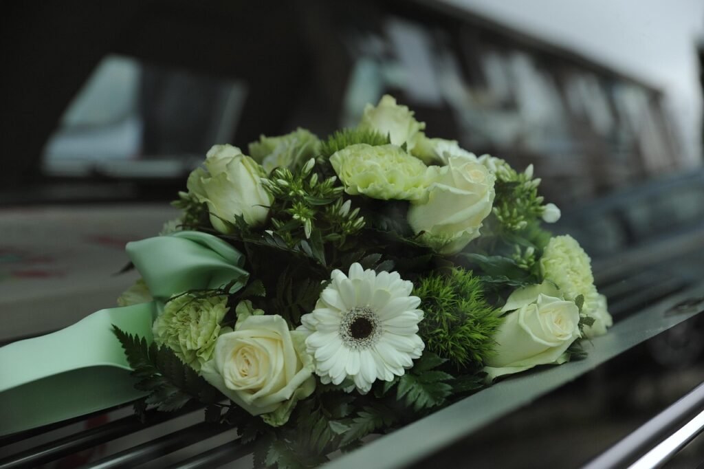 artificial funeral flowers over fresh funeral